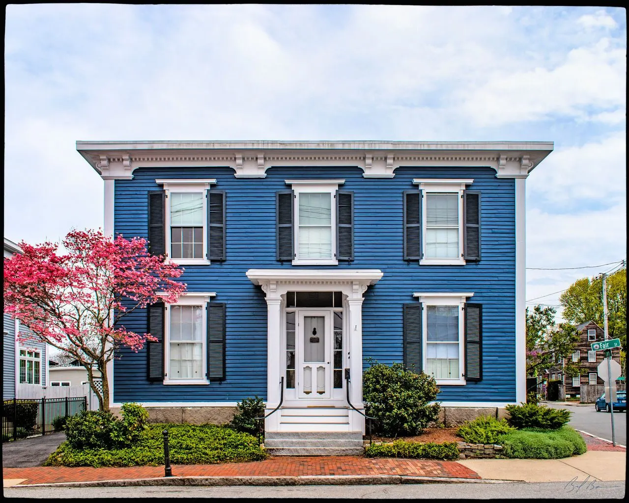 21 Fair Street, a blue Italianate house with a dogwood in bloom