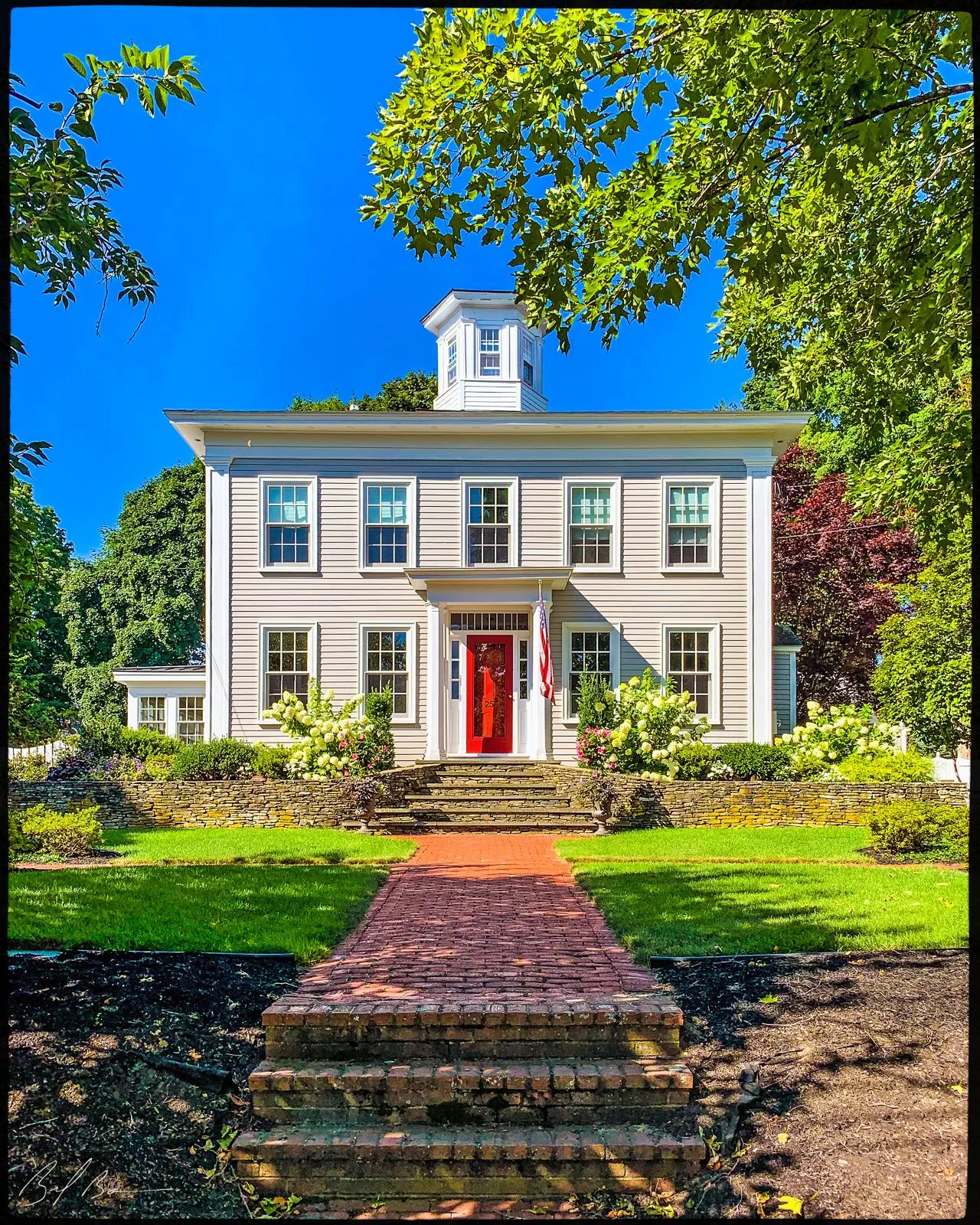 25 Walnut Street, a white Greek Revival house with a cupola and red door
