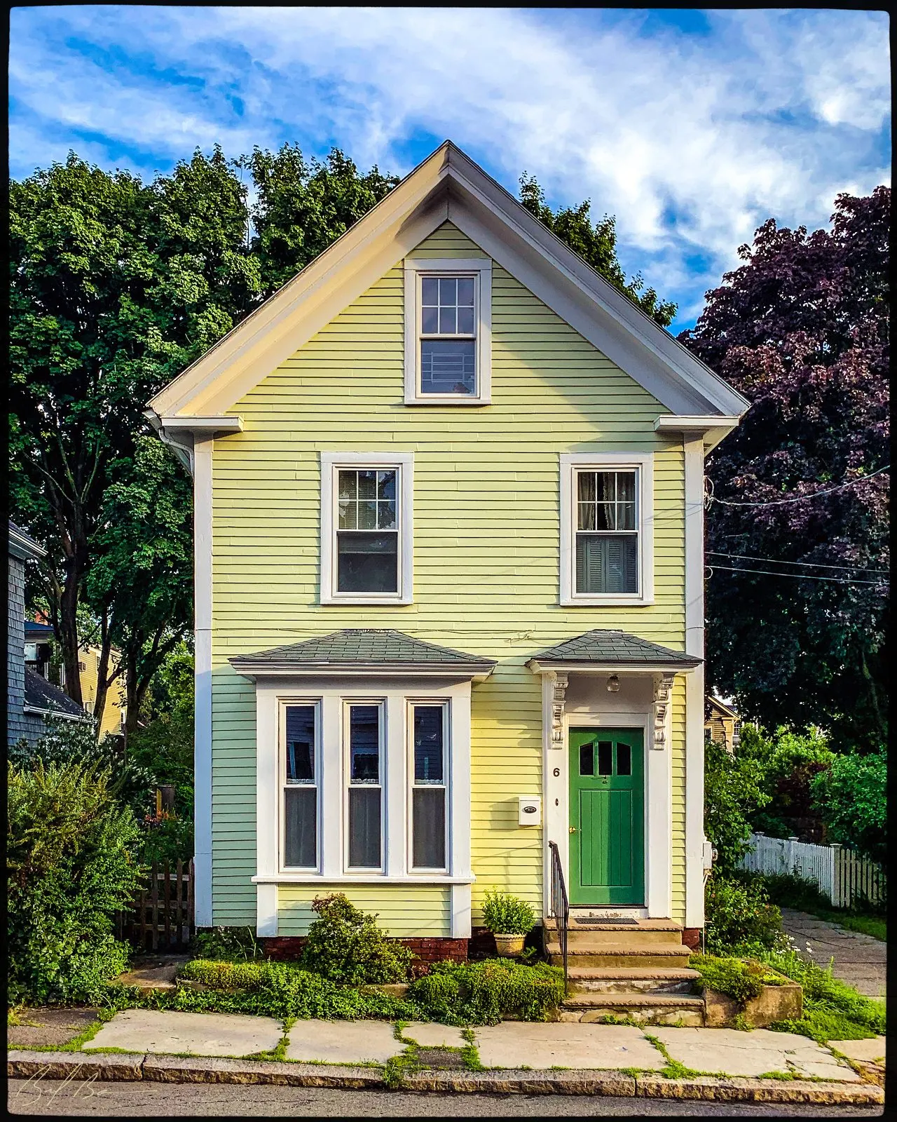 6 Carter Street, a yellow gable-front Italianate house with a green door